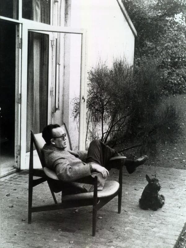 Finn Juhl sitting in the Chieftain Chair in front of his home in Ordrup north of Copenhagen.