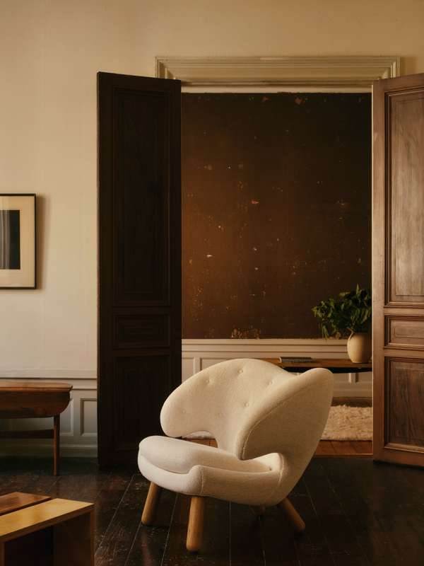 The Pelican Chair with walnut legs and upholstered in 'Moss' in the color '0004'.